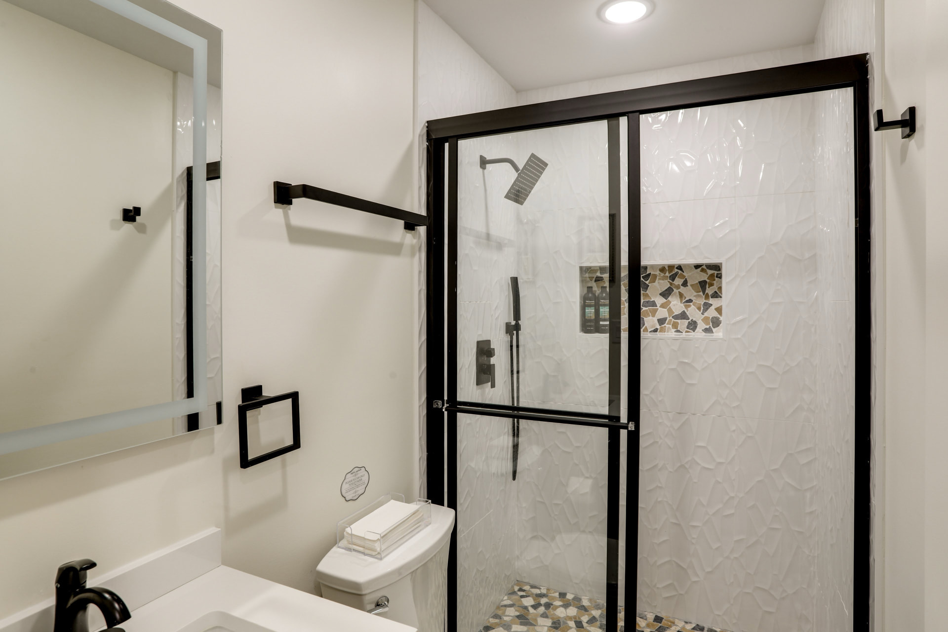 Second full bathroom at Cedarstone Retreat with a white textured-tile walk-in shower and black-framed glass door